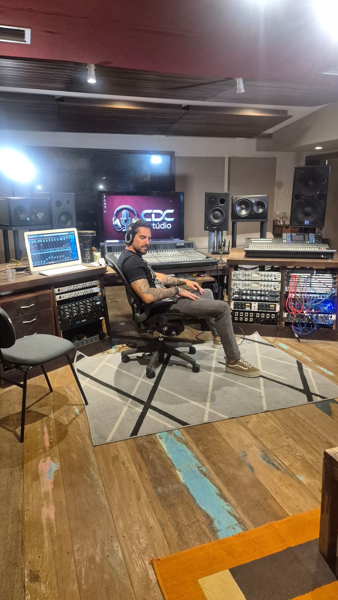 Produtor com headphone na mesa de mixagem do CDC Estúdio